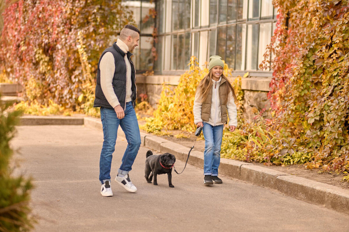 kız çocuğu ve adam köpek gezdiriyor